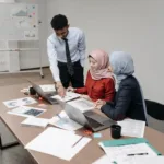 Tim profesional berdiskusi dan merencanakan tugas di meja kantor